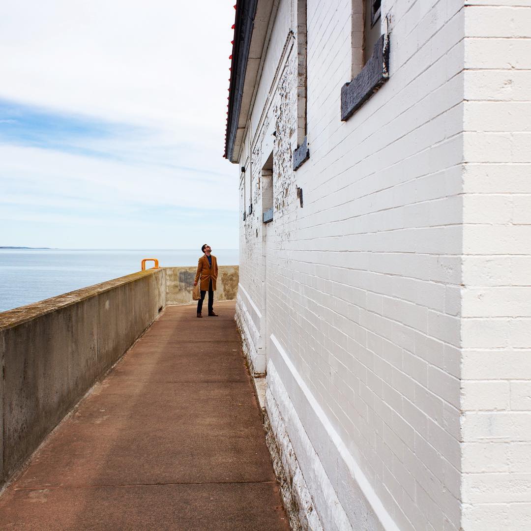 Adam exploring beside a large white building near the water